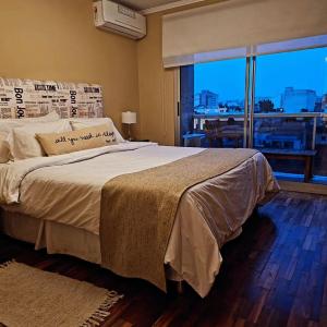a bedroom with a large bed with a large window at Departamento Caseros in Salta