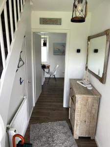 a hallway with a staircase with a mirror and a table at Haus Alexandra in Dornum