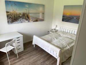 a bedroom with a bed and a desk and a table at Haus Alexandra in Dornum