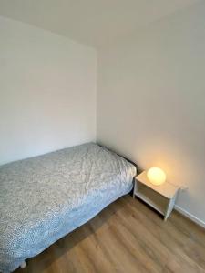 a small bedroom with a bed and a side table at T2 échappée belle Albi in Albi