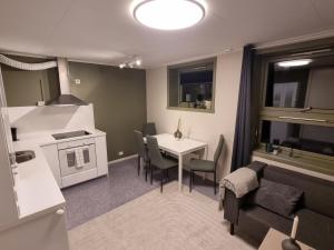 a kitchen and living room with a table and a couch at Small cozy 3 bed appartment in Tromsø