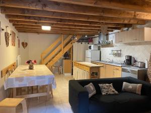 a living room with a couch and a table in a kitchen at Gites Ardoise et Girolle Formiguères in Formiguères