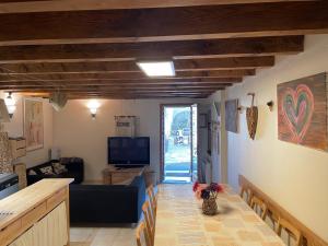 a living room with a couch and a table and a television at Gites Ardoise et Girolle Formiguères in Formiguères