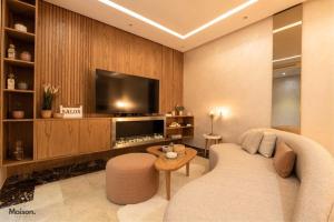 a living room with a couch and a flat screen tv at Luxury Suite Mannesmann - Seaview in Mohammedia