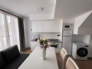フエンヒロラにあるNew Central & Cosy Apartments at Fuengirola Beachの花瓶に花が飾られたテーブルのあるキッチン