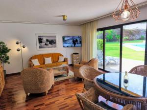 ein Wohnzimmer mit einer Couch und einem Tisch in der Unterkunft Elegant and Peaceful Aparments with Pool and Garden in Puerto de la Cruz
