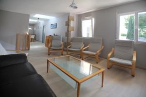 a living room with a glass coffee table and chairs at Maison avec piscine 10 couchages in Pornichet
