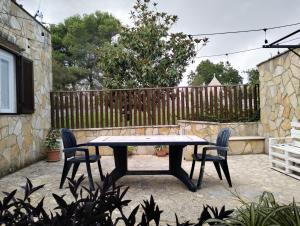 a table and chairs in a backyard with a fence at La dépendance in Noci +3 photos