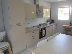 a kitchen with white cabinets and a table with chairs at Maison avec piscine 10 couchages in Pornichet