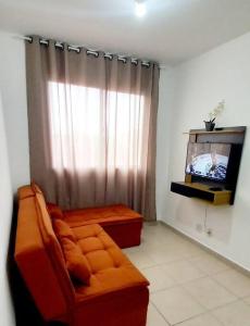 a living room with a couch and a tv at Apto 2Q Sala Cozinha Garagem Wifi Shopping in Taubaté