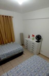 a bedroom with a bed and a dresser at Apto 2Q Sala Cozinha Garagem Wifi Shopping in Taubaté +16 photos