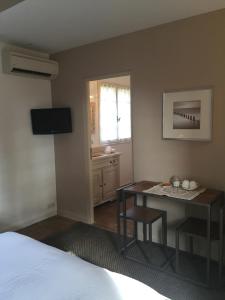 una camera da letto con un letto, una scrivania e una televisione di Villa Saint Paul a Saint-Paul-de-Vence