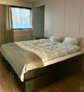 Una cama grande en un dormitorio con ventana. en Kaamos Old House, en Rovaniemi