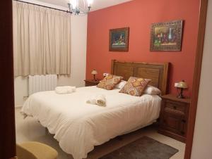 Electra IndustrialにあるCasa Rural Río Fríoのベッドルーム1室(オレンジ色の壁の大きな白いベッド1台付)