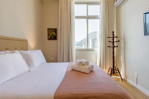 Un dormitorio con una cama blanca con una toalla encima. en Agradável apartamento próximo a Praia de Ipanema, en Río de Janeiro