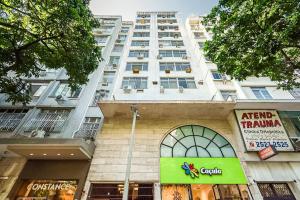 un edificio blanco alto con un cartel delante en Agradável apartamento próximo a Praia de Ipanema, en Río de Janeiro