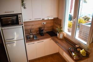 a kitchen with a white refrigerator and a window at Estevi Apartment in Kavala