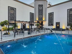 a swimming pool with chairs and a table in a building at مورايا Murraya in Abyār ‘Alī