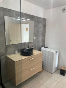 a bathroom with a sink and a mirror at Appartement T3 climatisé,balcon, classé 3 étoiles in Le Boulou +14 photos