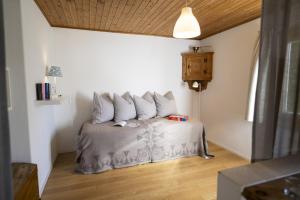 a bedroom with a bed with four pillows on it at Chasa Arquint in Sent