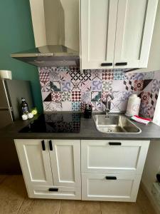 a kitchen with white cabinets and a sink at Jaky Maison Torino, Cozy & Modern Stay in Turin