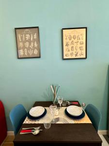 a wooden table with plates and glasses on it at Jaky Maison Torino, Cozy & Modern Stay in Turin