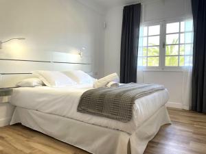 a bedroom with a large white bed and a window at Apartamento en Tenerife - Alcalá - con vistas al Teide in Alcalá