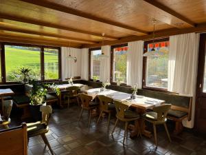 a restaurant with tables and chairs and windows at Pension Sonneck in Pfarrwerfen