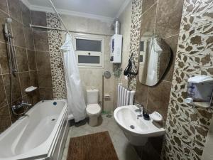 Un baño con bañera, inodoro y lavabo. en Elegant Guest House, en New cairo