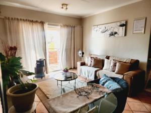 una sala de estar con un sofá y una mesa en Sable woods, en Pretoria