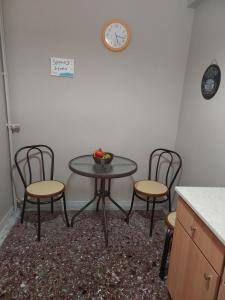 a table with three chairs and a clock on the wall at Spyros Studio in Paleo Tsifliki +10 photos
