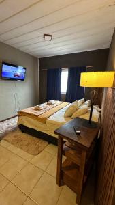 a bedroom with a bed and a table with a lamp at Hospedaje "Room" in El Chalten