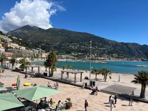 een groep mensen die op een strand bij het water lopen bij B&B tra i tetti in Menton