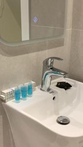 a bathroom sink with blue glasses and a faucet at فهد سويت للاجنحه الفندقيه ZR apartments in Riyadh +41 photos