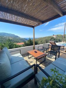a patio with blue couches and a wooden table at Villa Libra-Skiathos in Skiathos Town +9 photos