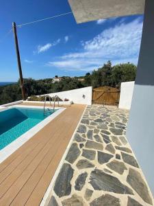 a house with a swimming pool and a wooden deck at Villa Libra-Skiathos in Skiathos Town