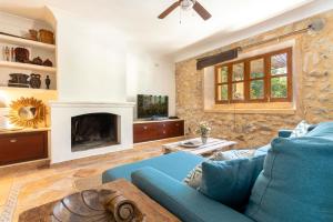 a living room with a blue couch and a fireplace at Finca Son Barbot by homevillas360 in Sant Llorenç des Cardassar