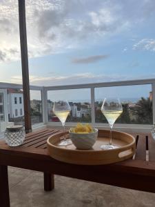 a table with two wine glasses and a bowl of food at Casa Branca in Ponta do Sol