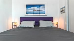 uma cama com uma cabeceira roxa num quarto em Highest penthouse with best skyline & sea views em Benidorm mais 50 fotografias