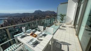 uma varanda com mesa e cadeiras em um prédio em Highest penthouse with best skyline & sea views em Benidorm