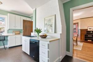 a kitchen with green walls and white cabinets at Entire Historic Home in Portland West End in Portland +26 photos