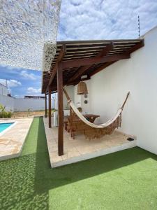 a hammock under a pergola next to a house at Casa Macao Tibau do Sul in Tibau do Sul