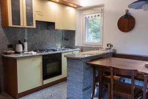 eine Küche mit einer Theke und einem Holztisch in der Unterkunft Casa Schiappo Montagna Natura e Relax. in Iselle