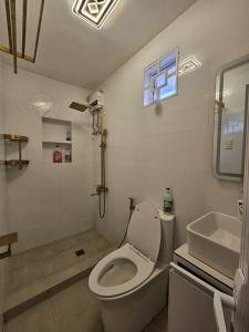 a white bathroom with a toilet and a sink at Family Friendly House in Malolos