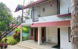 a house with a red roof and a staircase at Loveshore Marari in Mararikulam