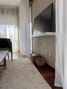 a living room with a flat screen tv on a shelf at Apartamento Galeguiña in Vigo
