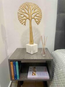 ein Holzbaum auf einem Tisch neben einem Bett in der Unterkunft Agradable depto con estacionamiento y portón eléctrico in Guasave