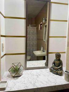 ein Badezimmer mit einem Spiegel und einer Statue auf einer Ablage in der Unterkunft Agradable depto con estacionamiento y portón eléctrico in Guasave