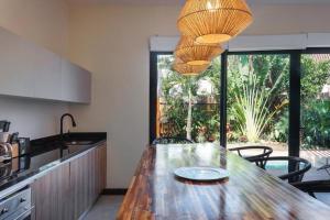 a kitchen with a table with chairs and a large window at Increíble Villa 2 piscinas 4hab hasta 14 personas in Tulum