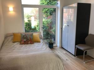 a bedroom with a bed and a sliding glass door at The Coach House, GUILDFORD in Guildford